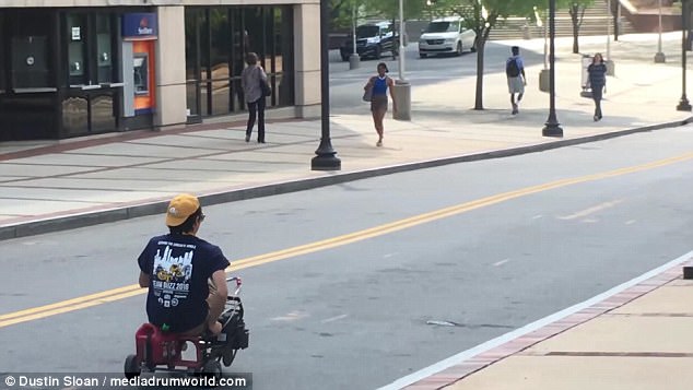 Footage shows the student drive down a main road in Atlanta, Georgia, on his unique motorised trike