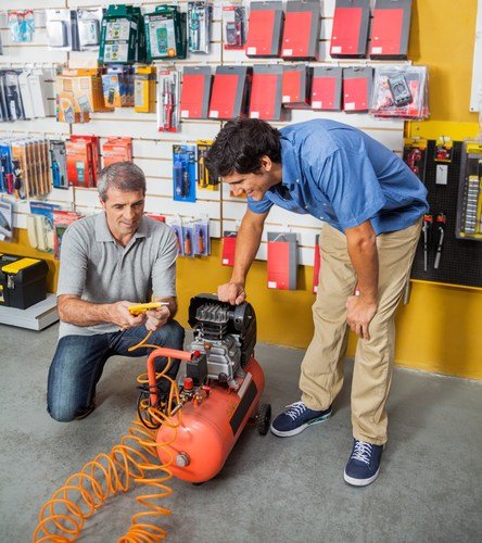 image of two men looking at a horizontal air compressor at a hardware store